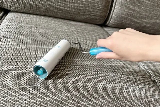 水色のカーペットクリーナーでソファを清掃している