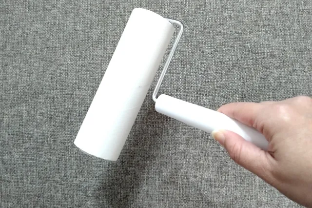 白色のカーペットクリーナーでソファを清掃しようとしている