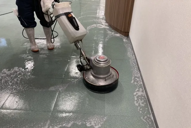 業務用のワックスがけ機械で床のワックスがけをしている清掃業者