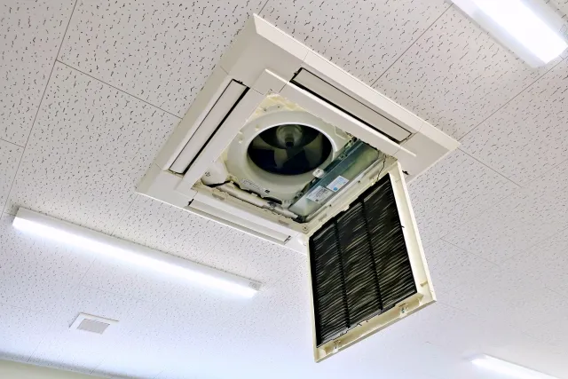 天井に設置されている業務用エアコンを開けているところ