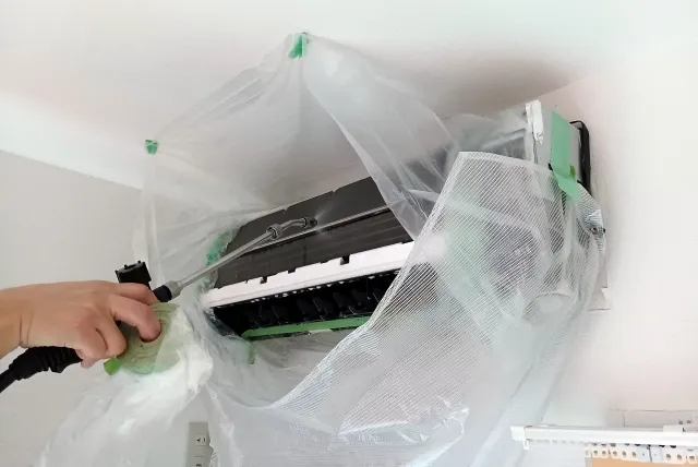 家庭用エアコンを解体して洗浄作業している様子